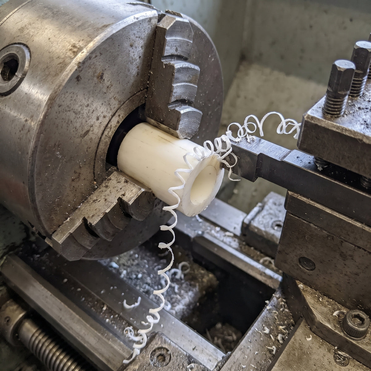 Natural acetal tube being turned to size on a lathe