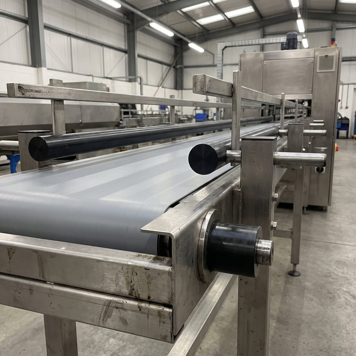 Black acetal rod used as low-friction guide rails and roller on a stainless steel conveyor