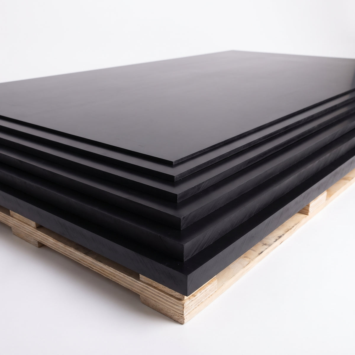 Stack of full-size black copolymer polypropylene sheets in 3mm to 12mm thicknesses on a pallet