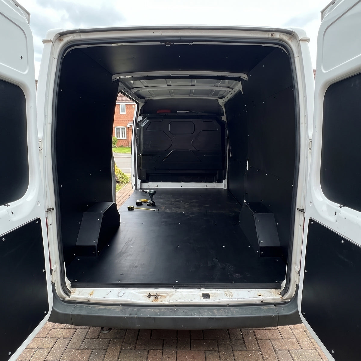 Van load area lined with black polypropylene sheet on the floor, walls and doors