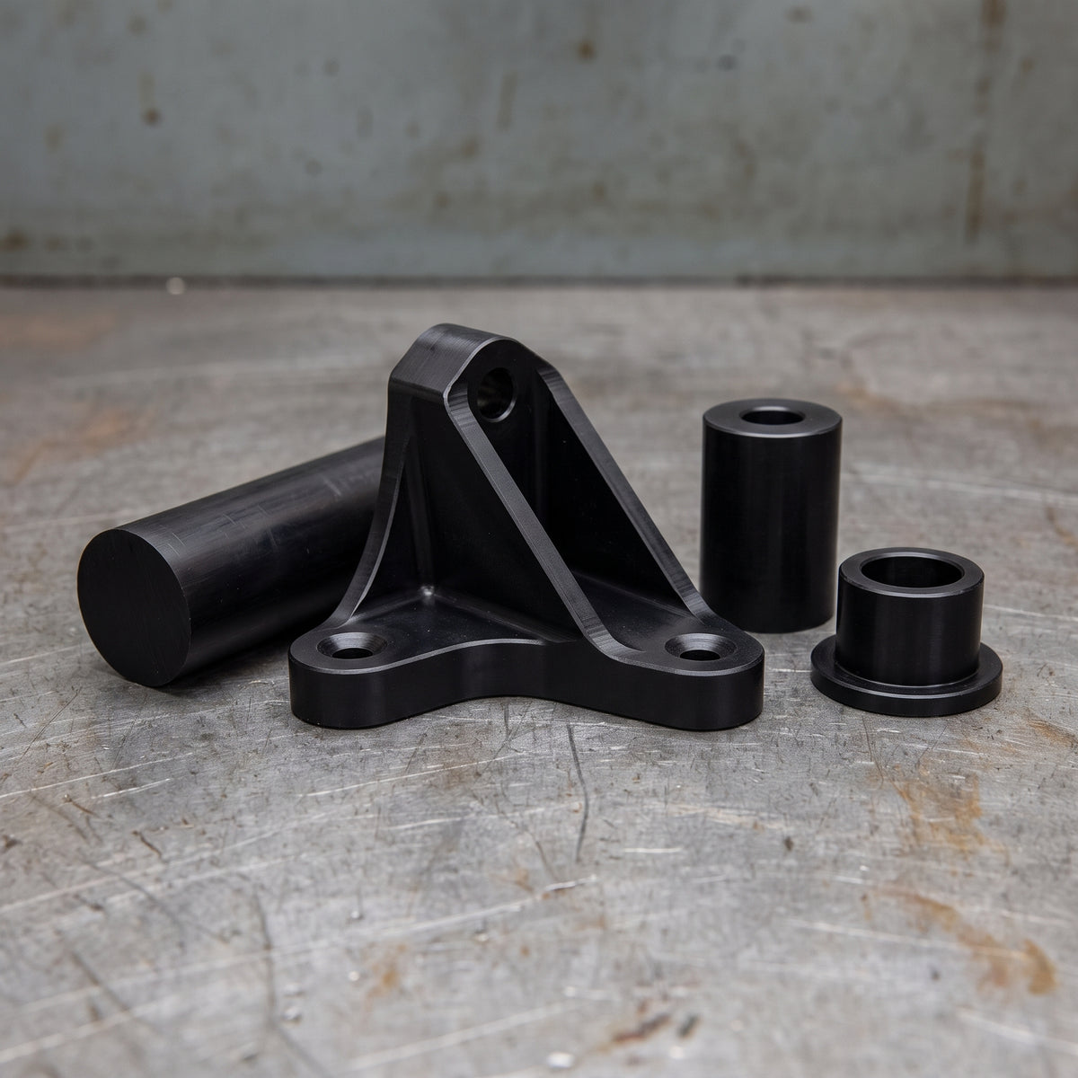 Bracket, spacer and flanged bush machined from black glass-filled Nylon 66 rod