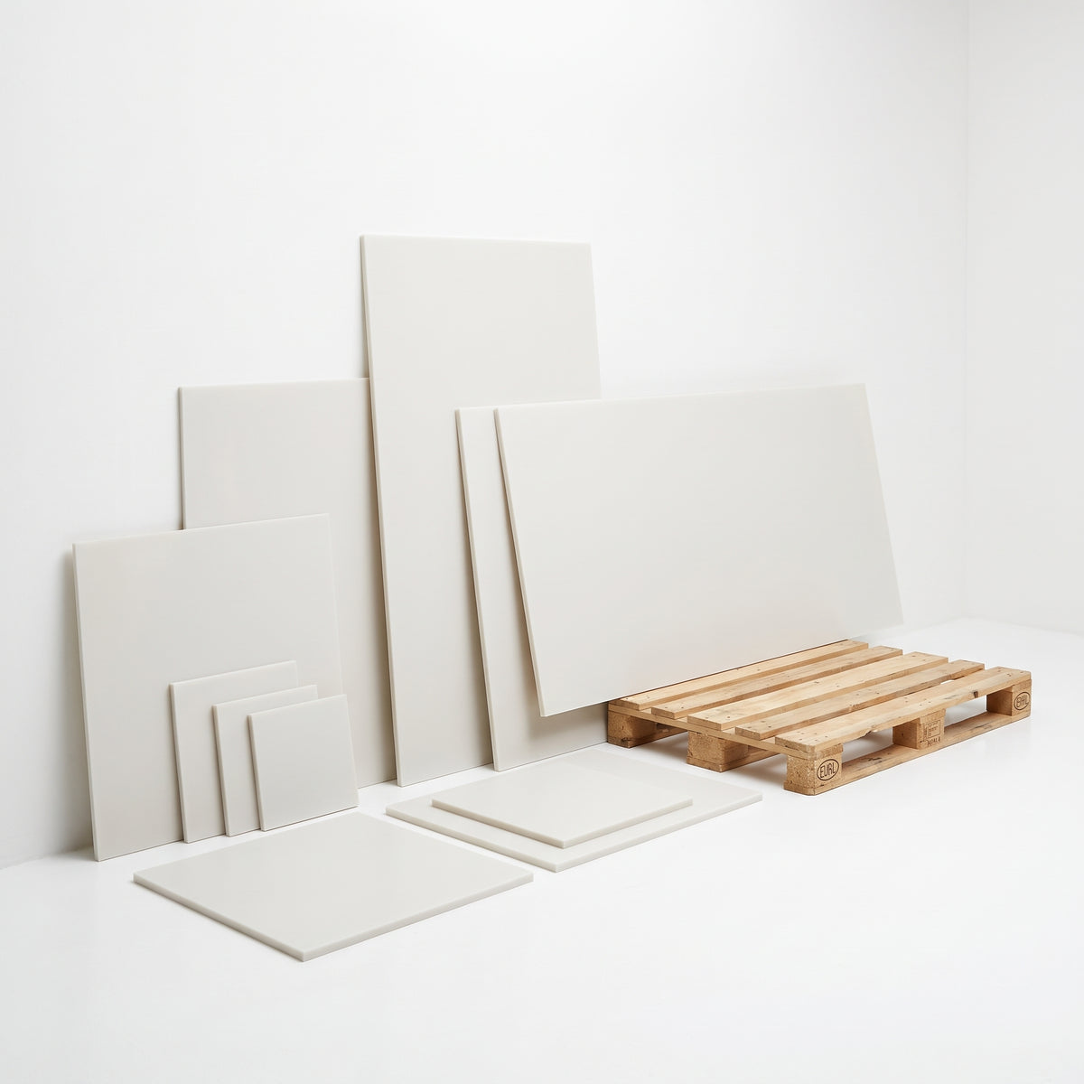 Natural HDPE sheet cut sizes from small squares to large panels next to a pallet for scale