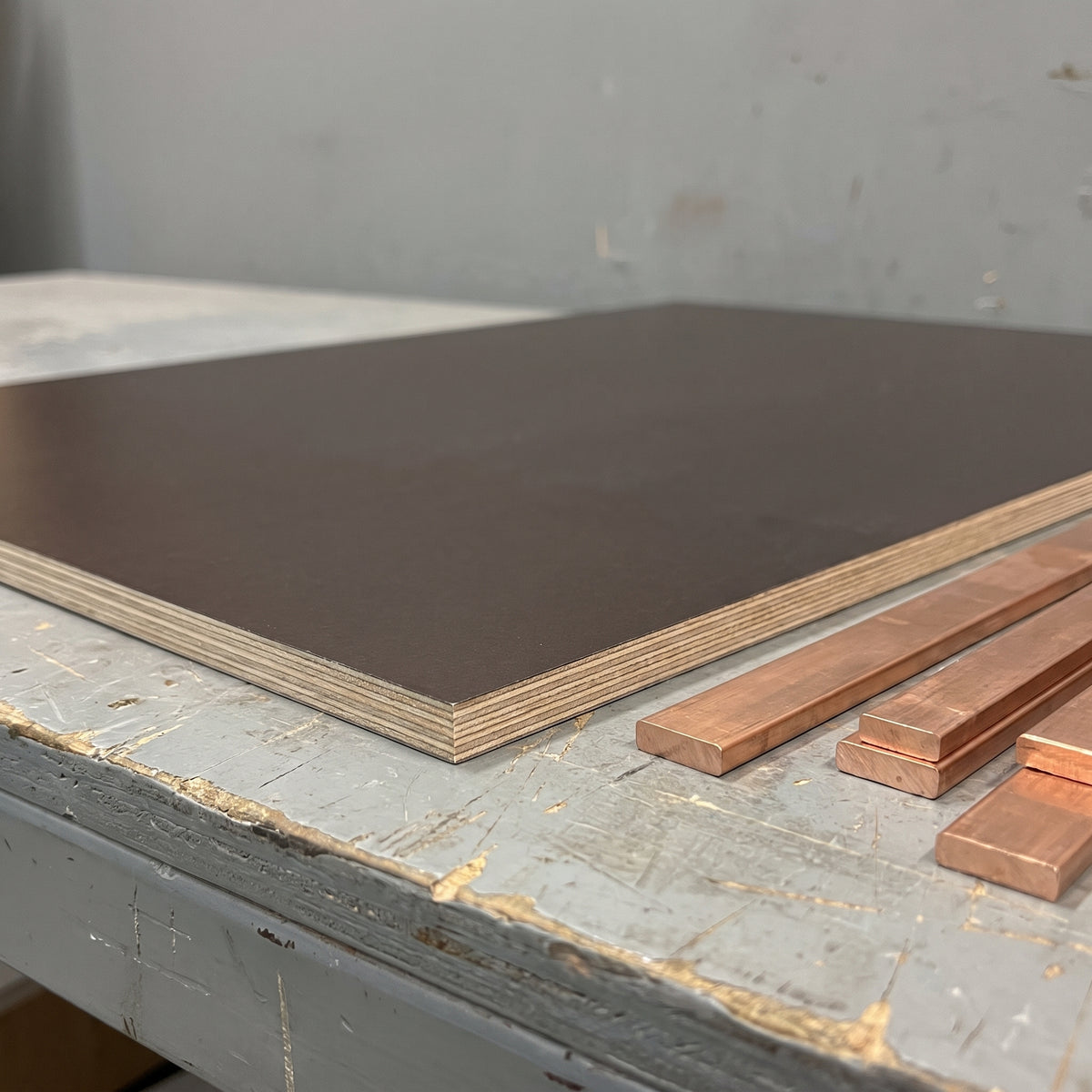 Tufnol Kite SRBP sheet on an electrical workbench beside copper busbars, ready for insulated busbar supports